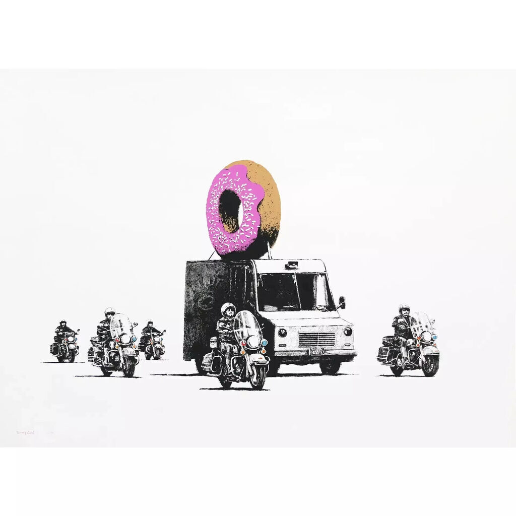 A large donut with pink frosting, white sprinkles and a brown half sits above a boxy van, with motorcyclists and their black-and-white motorcycles arranged around it.