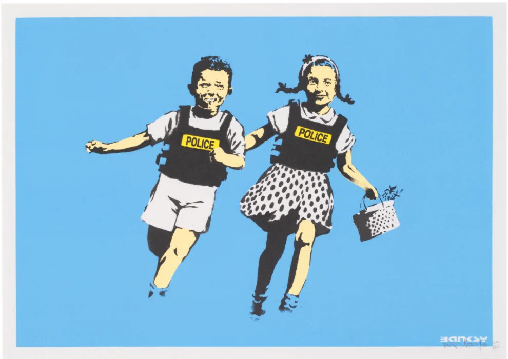 Two smiling children in police vests leap against a bright blue background.