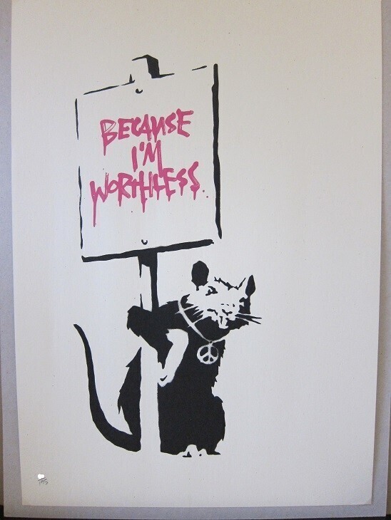 A black rat holds a sign reading Because I’m Worthless in pink.