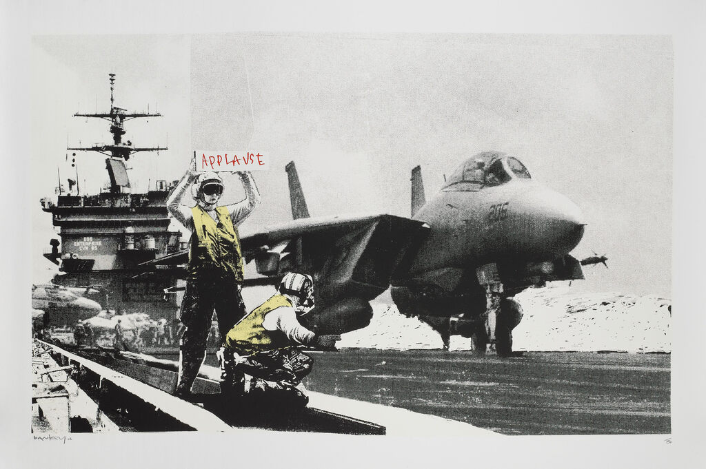 Scena monocromatica con aereo da combattimento e ponte di una portaerei, con accenti gialli sulle figure circostanti.
