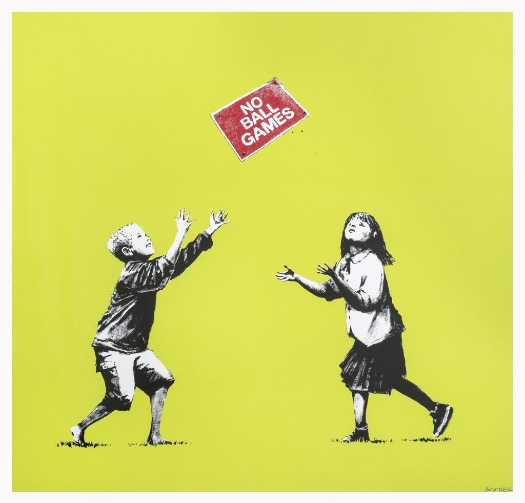 Two black-and-white children face a tilted red rectangular sign reading NO BALL GAMES against yellow-green; the boy raises both arms overhead, while the girl holds her hands in front of her.