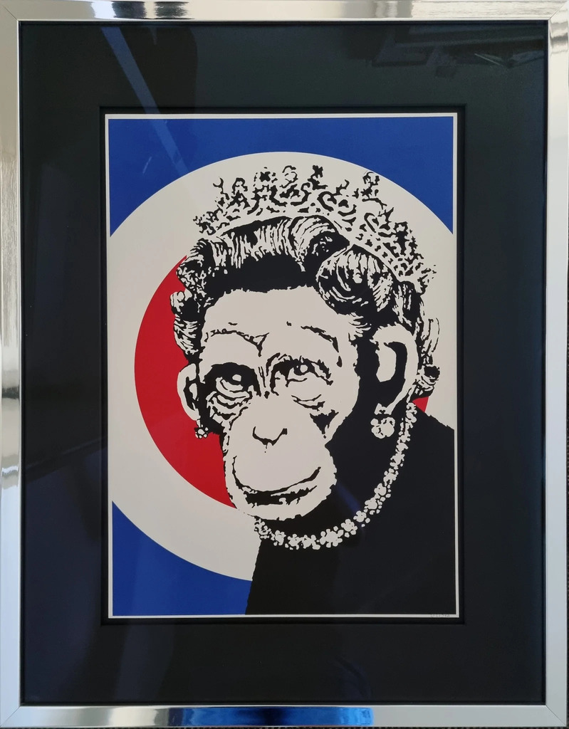 A black-and-white monkey face with crown and pearl necklace is centered over a blue, white and red circular ground.