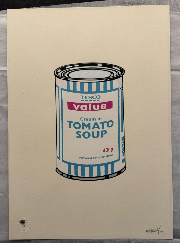 Single blue-striped tomato soup can centered on cream paper.