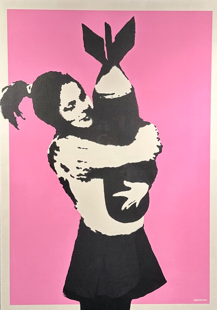 A girl in black and white embraces a large dark bomb against pink.