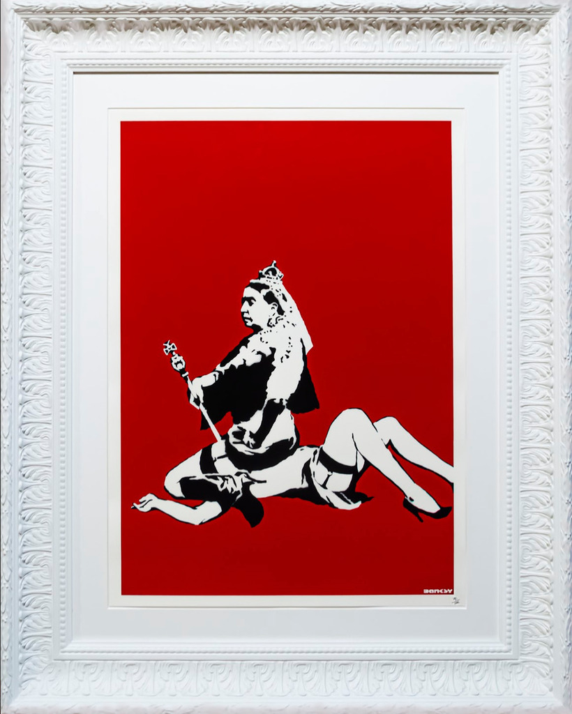 A white ornate frame surrounds a red print of a crowned woman seated on a reclining figure.