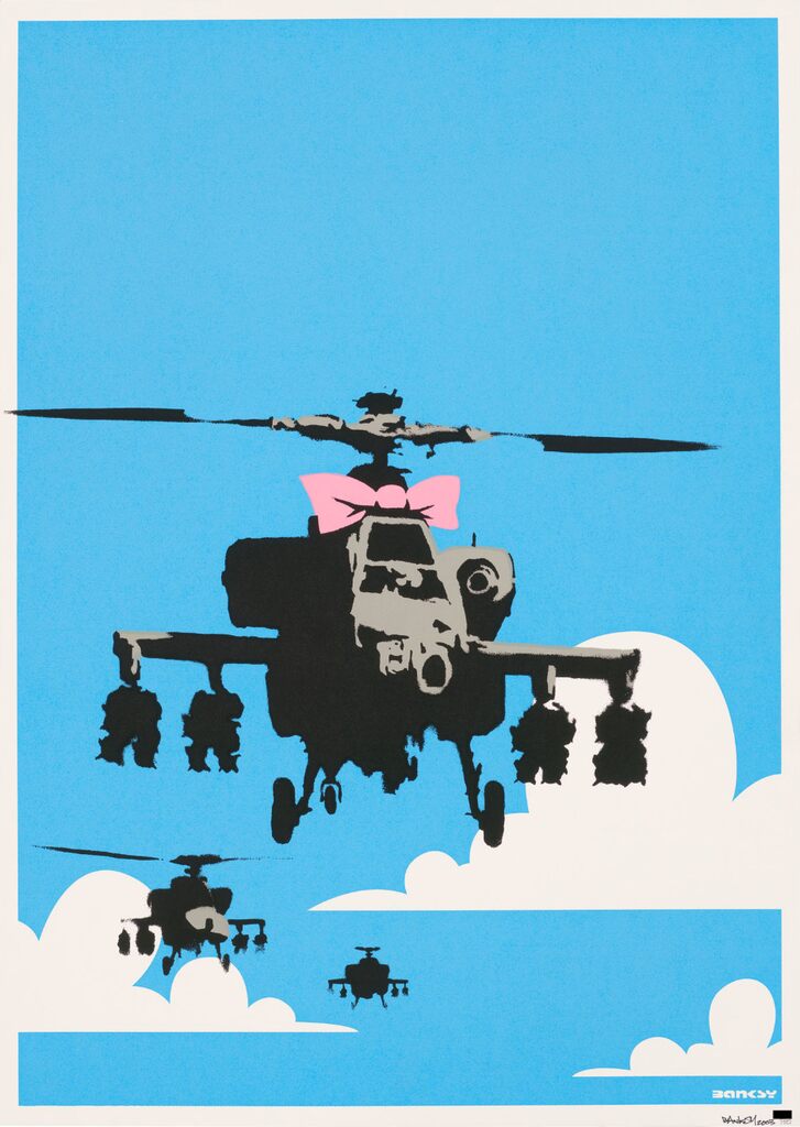 Three military helicopters appear among white clouds against bright blue; the large foreground helicopter has a pink bow above its cockpit.