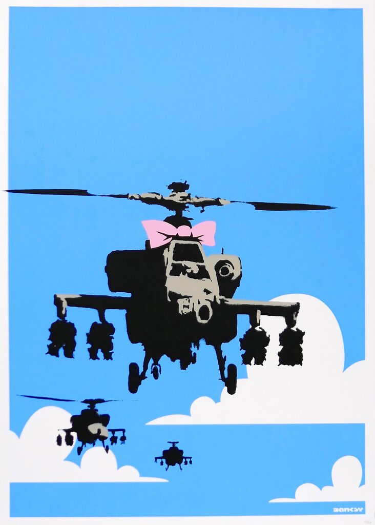 Three military helicopters appear among white clouds against bright blue; the large foreground helicopter has a pink bow above its cockpit.
