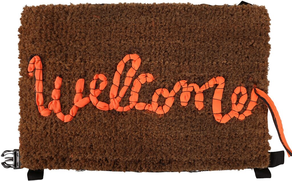 Brown doormat with Welcome spelled in orange rope and black straps below.