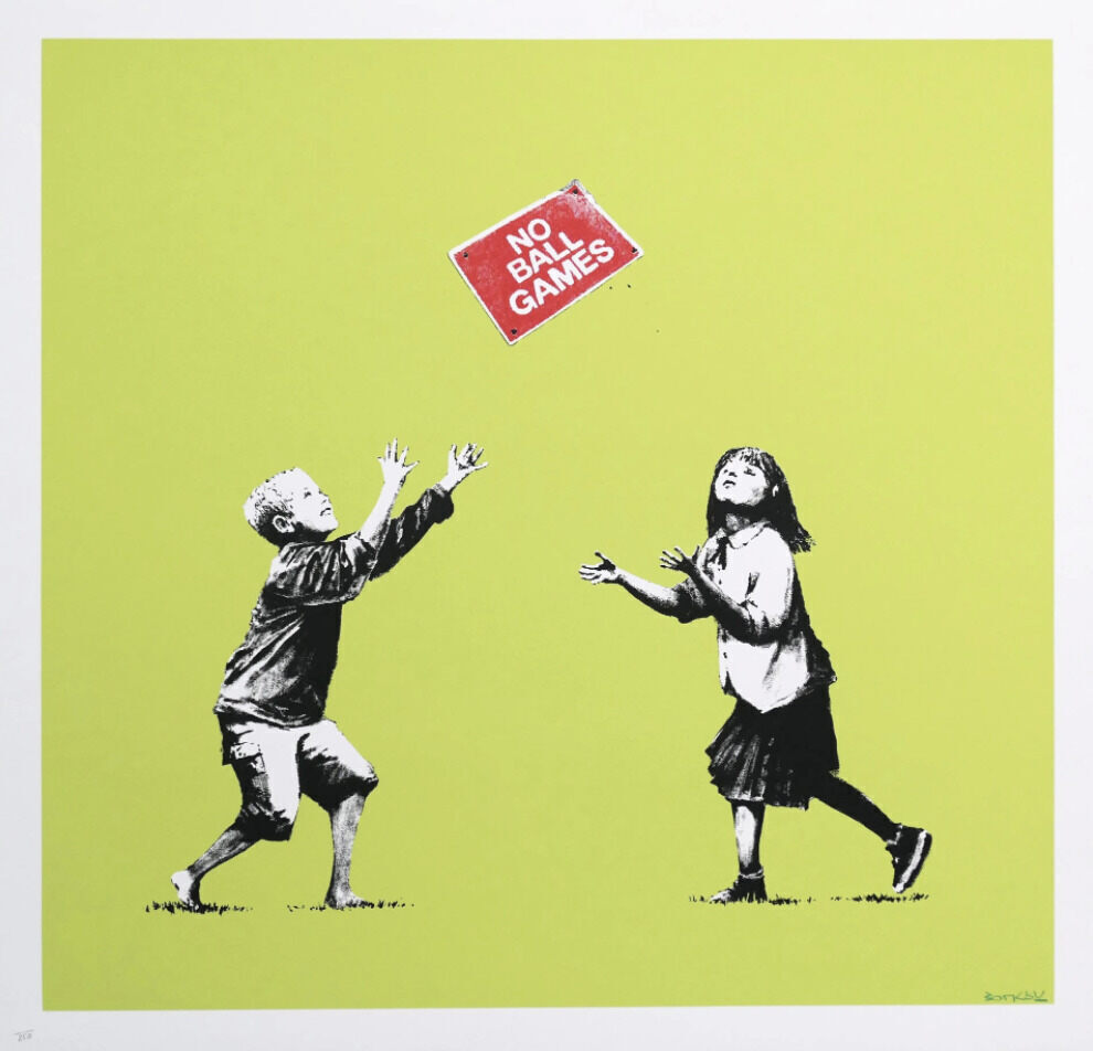 Two black-and-white children face a tilted red rectangular sign reading NO BALL GAMES against yellow-green; the boy raises both arms overhead, while the girl holds her hands in front of her.