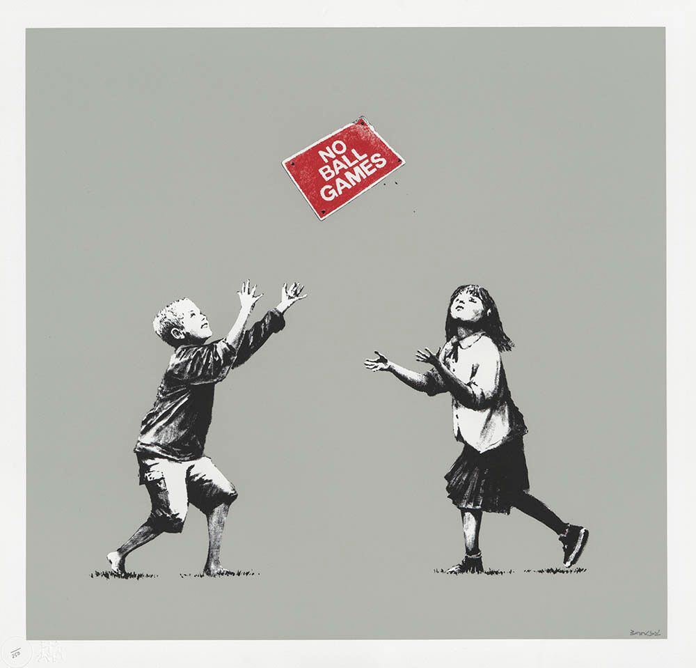 Two children tossing a red No Ball Games sign on grey.