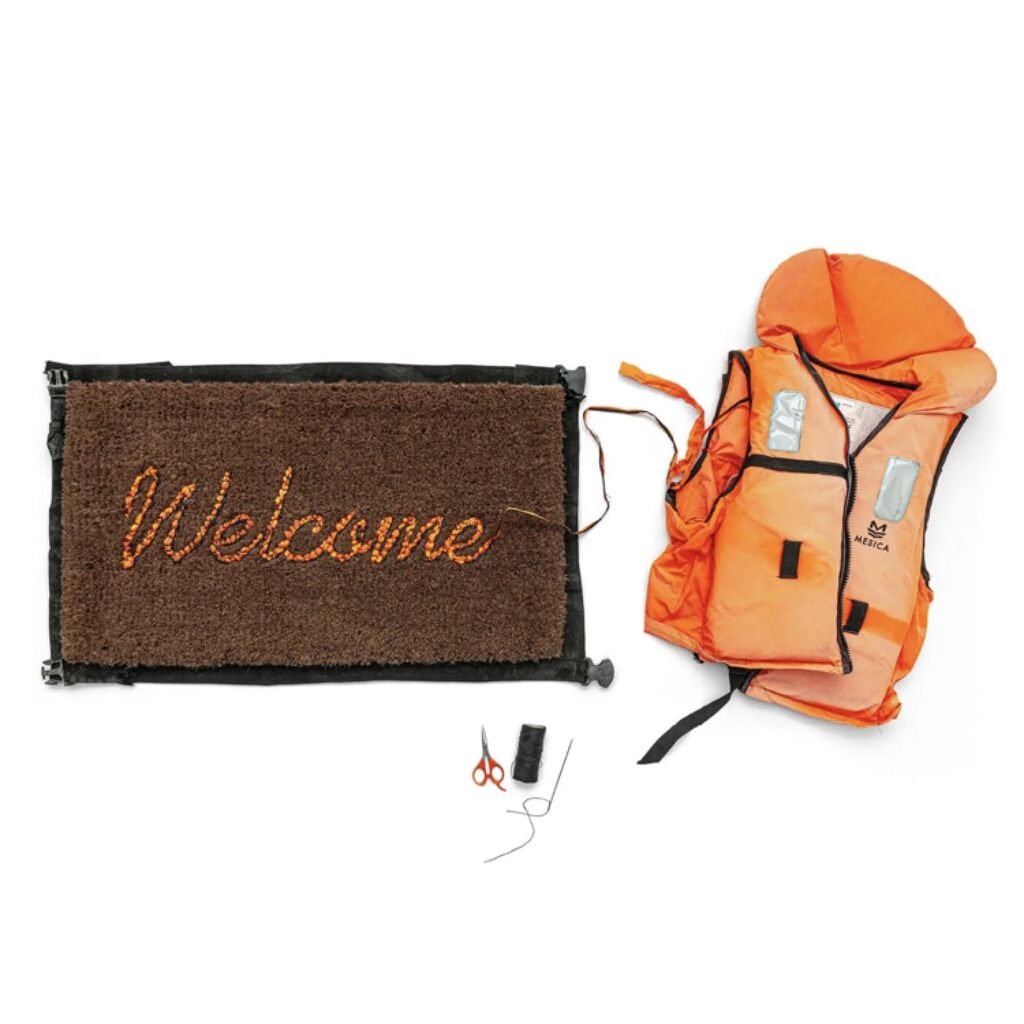 Brown welcome mat beside an orange life jacket, scissors and thread.