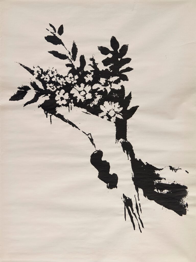 Black and white hand holding a bouquet on cream paper.