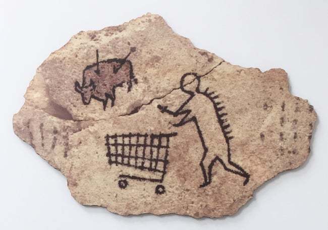 An irregular stone-like piece bears drawings of an animal, a person and a shopping trolley.