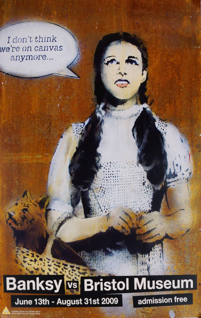 A Banksy Bristol Museum poster depicts a braided girl with a speech bubble against brown.